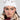 A person sporting the ASAP Vibes Embellished Beanie from the AKIRA Label and a leopard print faux fur coat radiates iconic vibes. They accessorize with hoop earrings and enhance their look with bold makeup—eyeliner and blush—as they pose against a plain background.