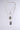 Introducing the "DOG TAG BUT MAKE IT CUTE NECKLACE," a stylish three-layer silver chain set featuring rectangular textured pendants that shimmer delicately against a simple gray backdrop. Each chain varies in length, producing a sophisticated cascading effect.
