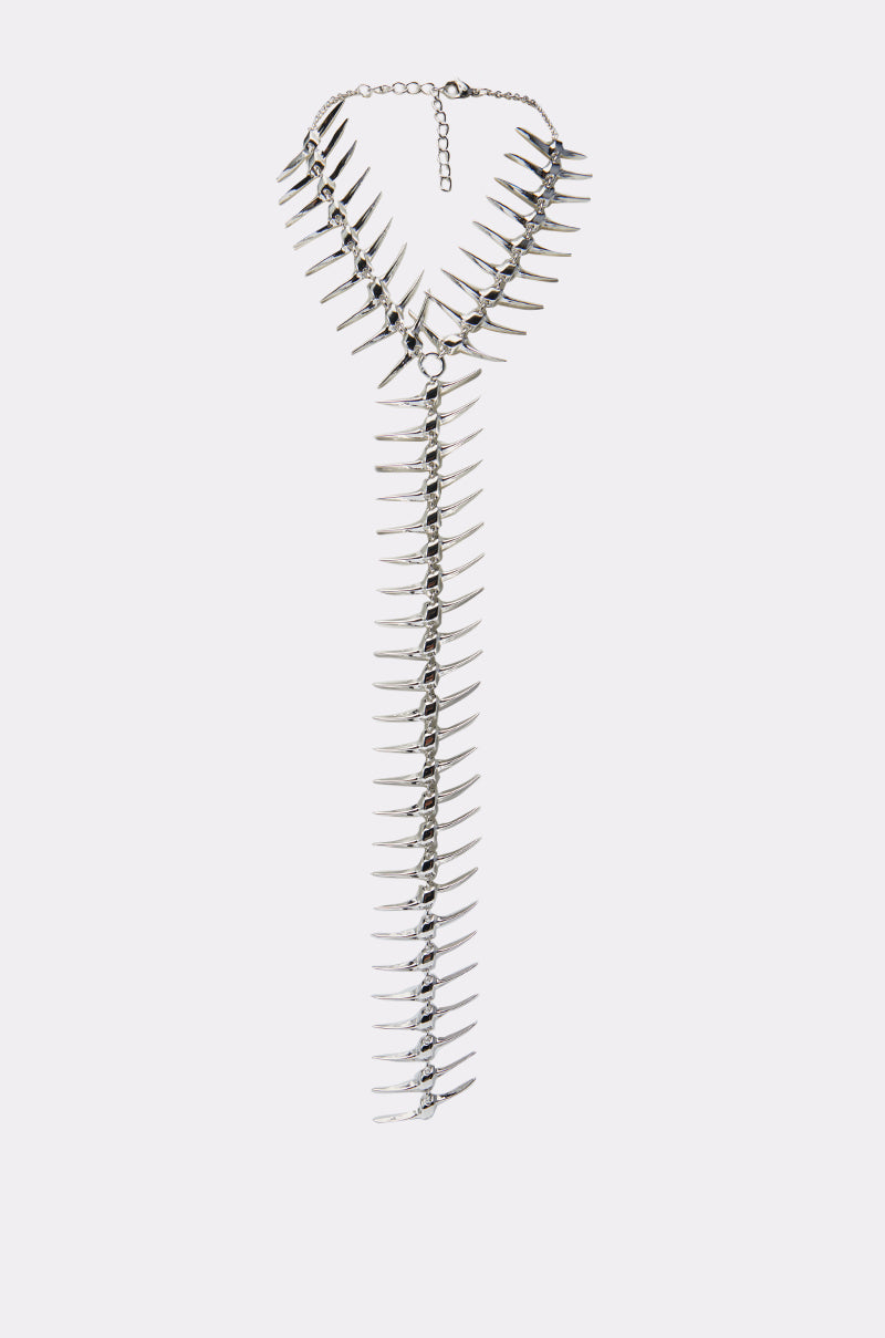 The ALL DOWN MY BACK STATEMENT NECKLACE features dramatic, multi-row V-shaped spikes and a long central strand, creating an edgy and unforgettable look.