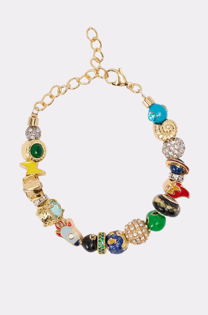 The SPACED OUT CHARM BRACELET is a gold-tone bracelet with uniquely shaped, textured beads in blue, green, red, and jeweled designs, shown on a white background. 0