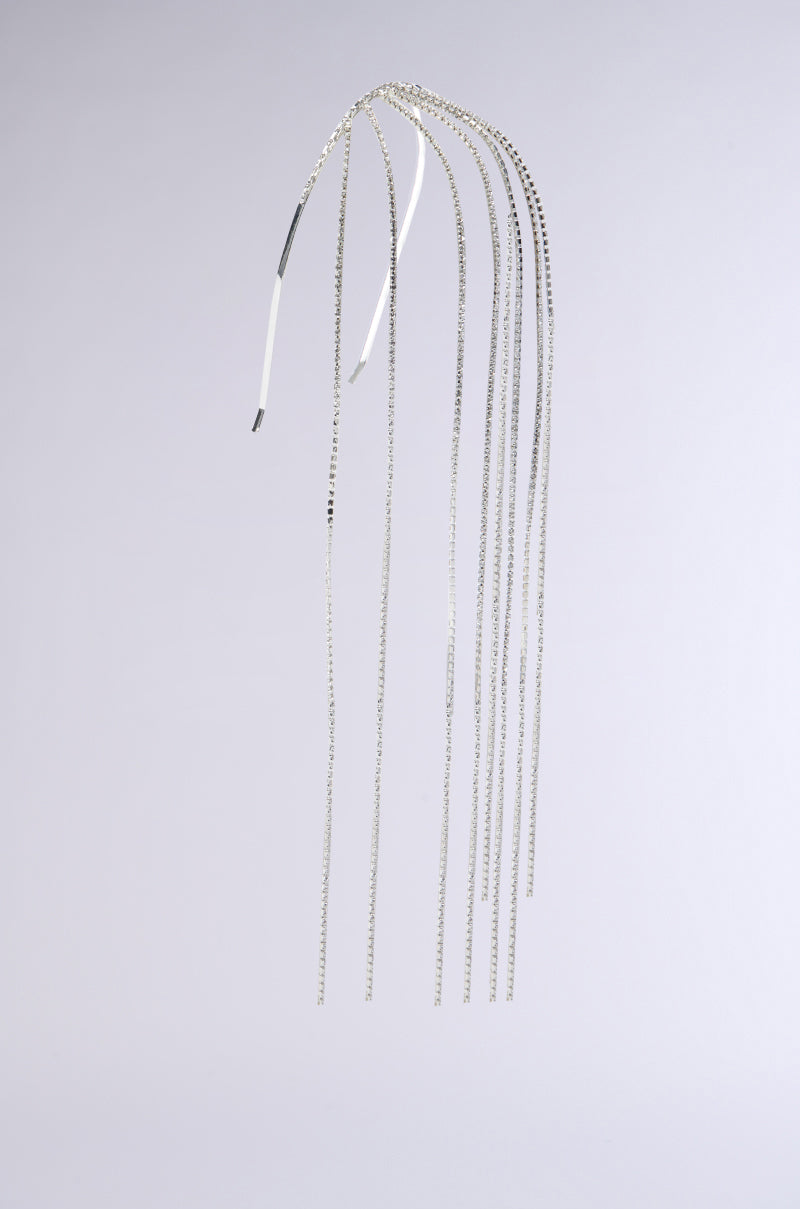 The ON MY MIND BLING HEADBAND, a minimalist silver accessory, features eight delicate chains adorned with subtle chain link details. This design creates an elegant and flowing appearance against a plain light gray background. 3
