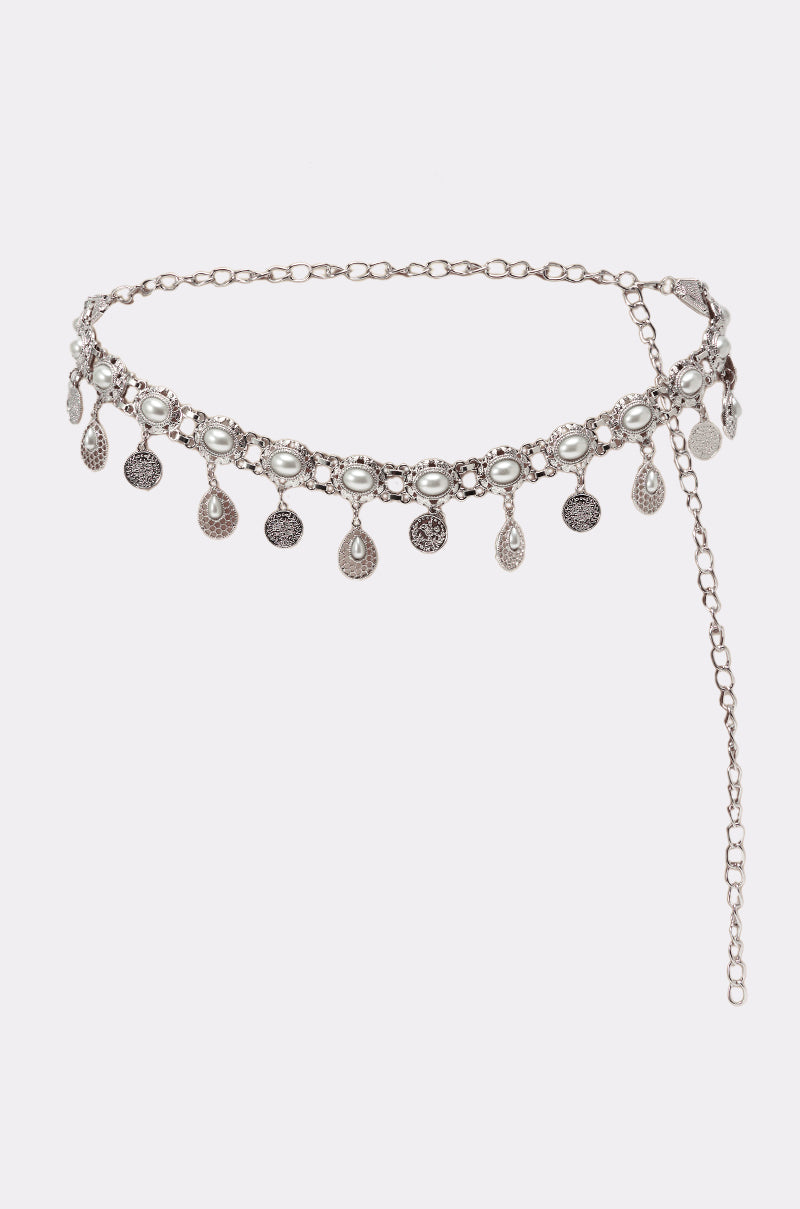 The ROCK YA BODY CHAIN BELT is a vintage-inspired accessory with a silver chain, white beads, dangling coins, teardrop charms, and an adjustable clasp with an extended fastening chain. 1