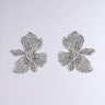 Discover the FLORAL DREAM EARRING: delicate flower-shaped pendants adorned with shimmering rhinestones, elegantly displayed on a simple gray background.