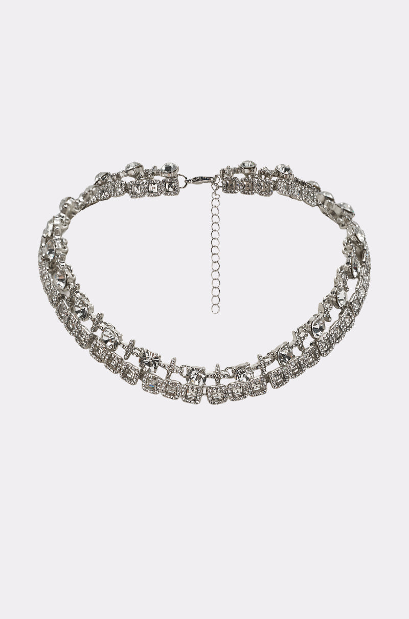 The BLING RING NECKLACE IN SILVER features two rows of clear rhinestones, an adjustable chain clasp, and is shown on a plain white background. 0