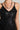 A person is wearing the BOUNDLESS LEATHER MINI DRESS, styled with a sleeveless black lace top featuring a floral cut-out pattern and accessorized with a silver chain necklace composed of large, interlocking circular links. The image is cropped to showcase only the upper torso and part of the neck.