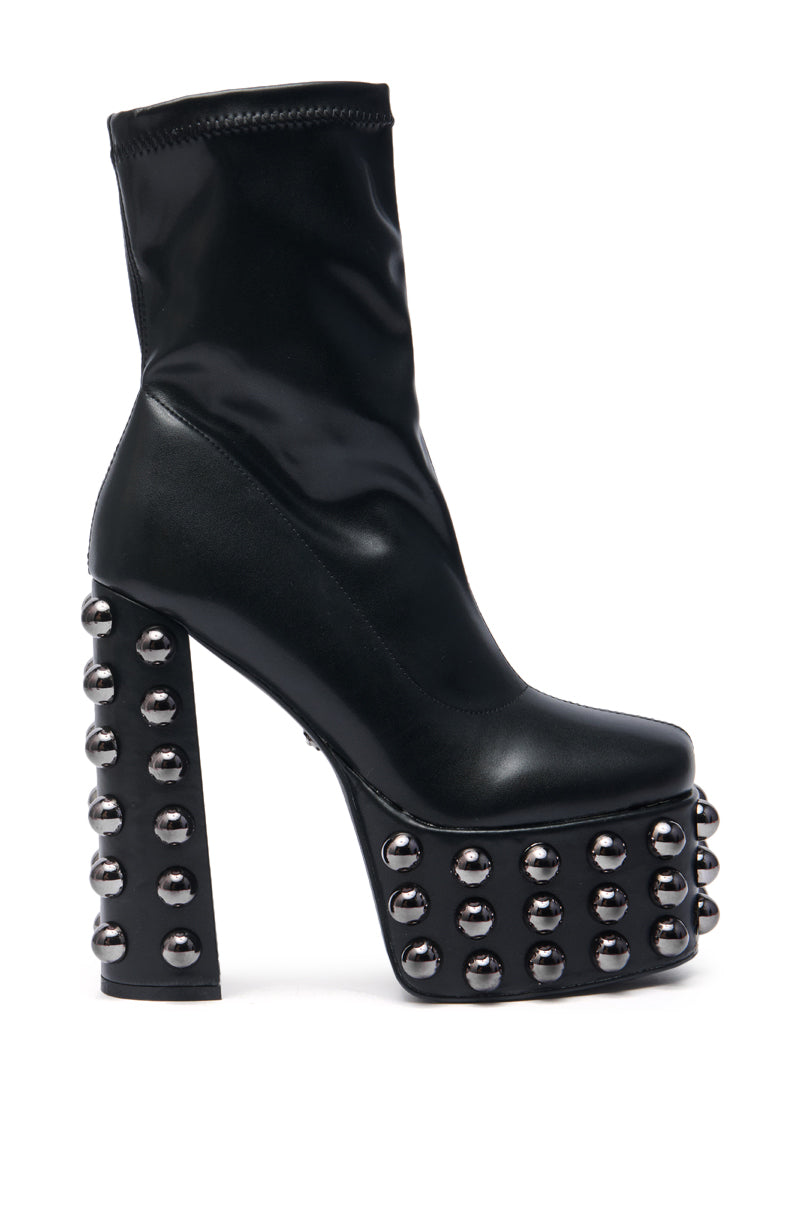 The AZALEA WANG AKITO BLACK GUN METAL STUDDED PLATFORM BOOTIE features a smooth black faux leather upper, chunky high heel, and gun metal studs on the heel and platform, with an above-ankle fit for a bold look.
