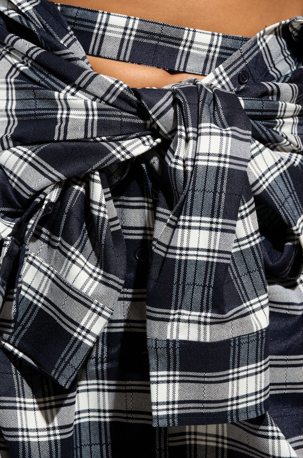 Close-up of the NEED YOU PLAID MAXI SKIRT in a black and white pattern, highlighting a large bow tied at the center. The flannel fabric provides a smooth texture with intersecting lines creating a grid-like design.