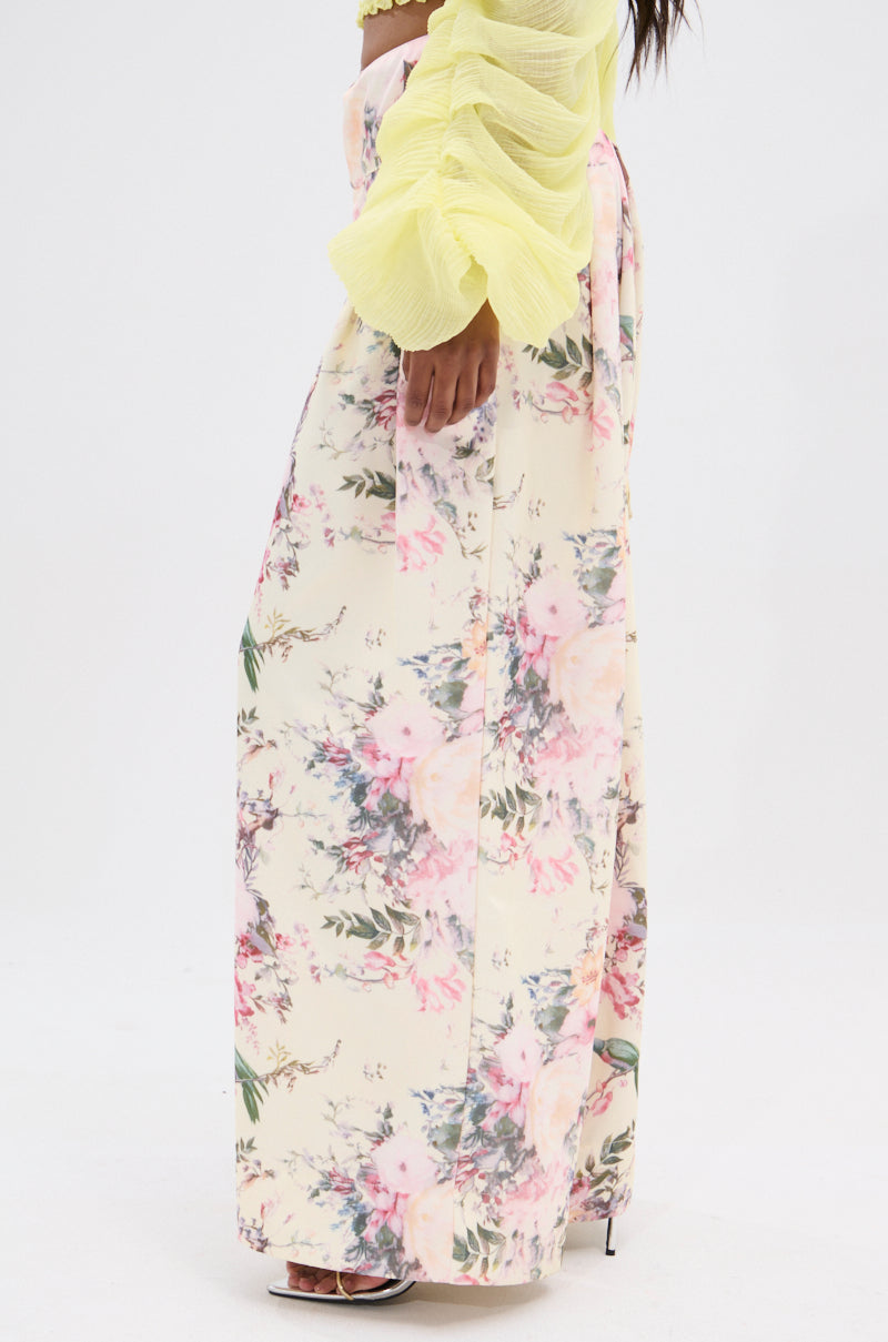 A person wears a yellow ruched sleeve top with a high-waisted SABRINA FLORAL WIDE LEG PANT, showcasing pink and green vintage-inspired floral prints on a light background, standing against a plain white backdrop. 3
