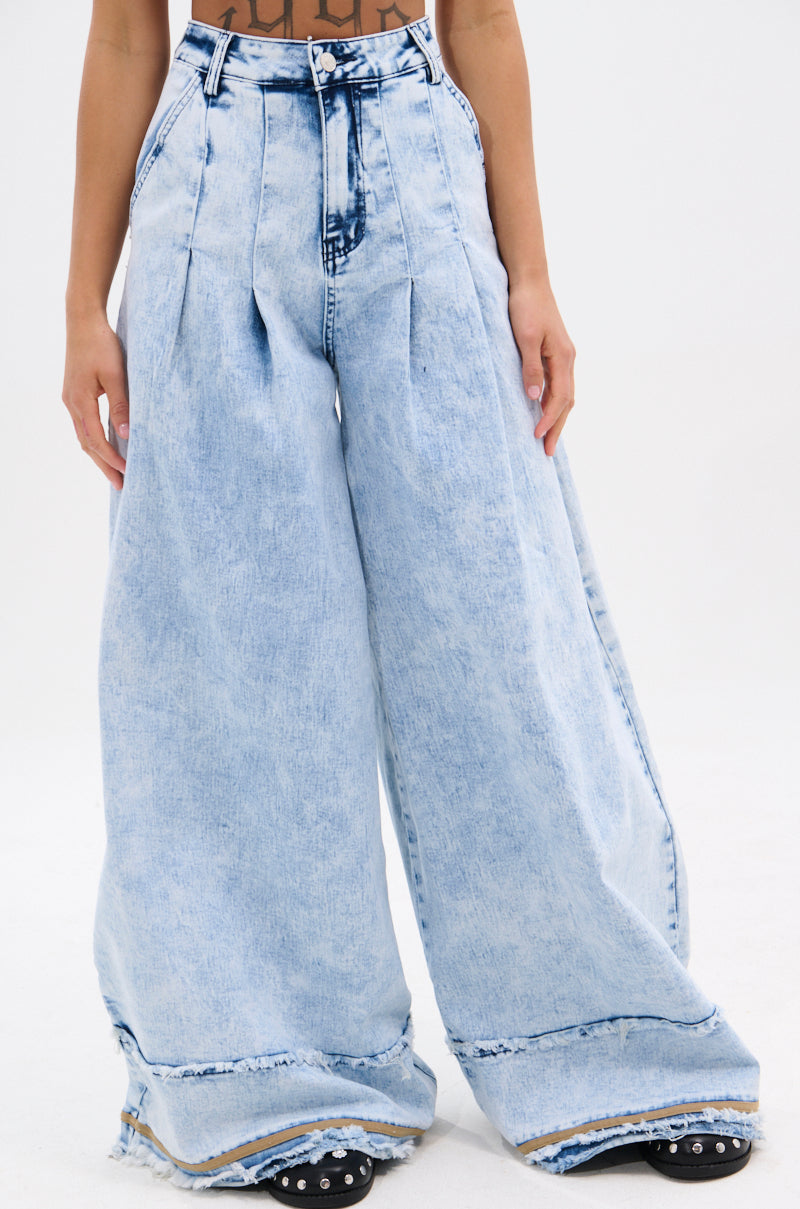 Wearing IN CHARGE WIDE LEG DENIM PANT: vintage-inspired high-rise waist and wide leg denim with frayed hems, paired with black studded shoes; upper body is partially visible against a plain white background.