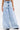 Wearing IN CHARGE WIDE LEG DENIM PANT: vintage-inspired high-rise waist and wide leg denim with frayed hems, paired with black studded shoes; upper body is partially visible against a plain white background.
