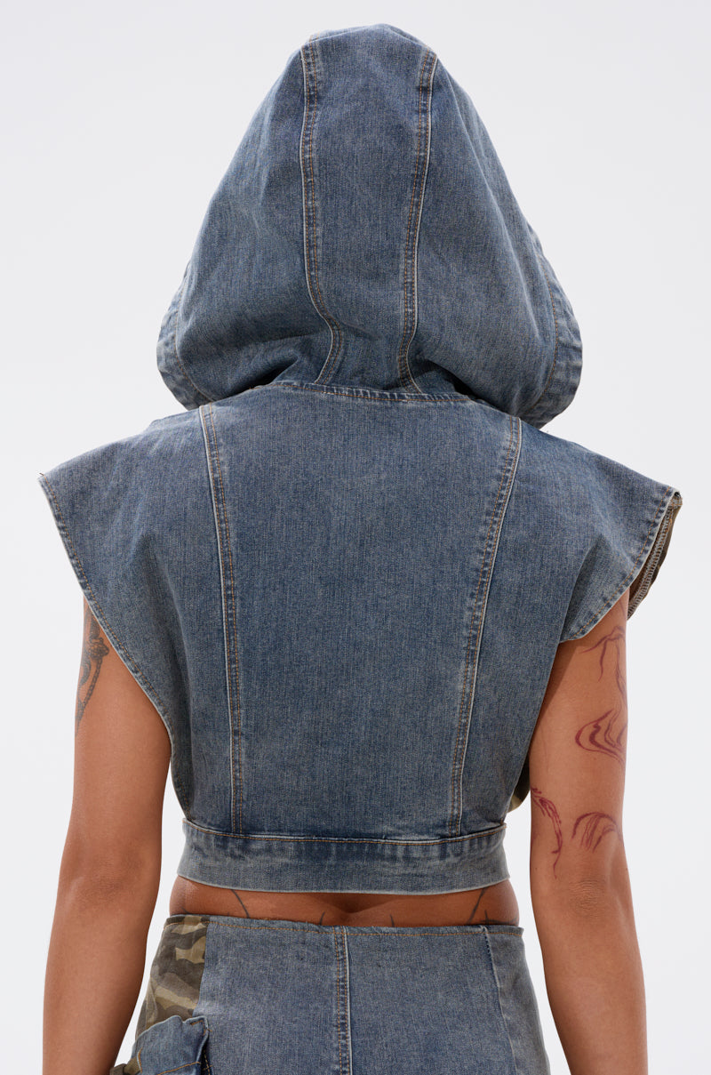A person seen from the back wears the DOWN AND DIRTY DENIM HOODED VEST with a large hood, paired with a matching denim skirt. Tattoos are visible on their arms. 6