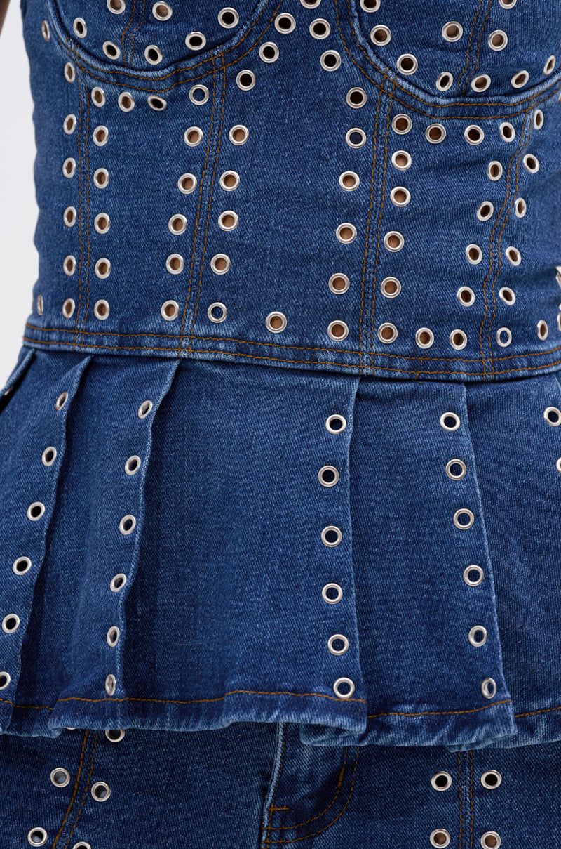 Close-up of the SOFIA DENIM CORSET WITH GROMMET, featuring a peplum hem, rows of grommet accents, and visible orange stitching. 7