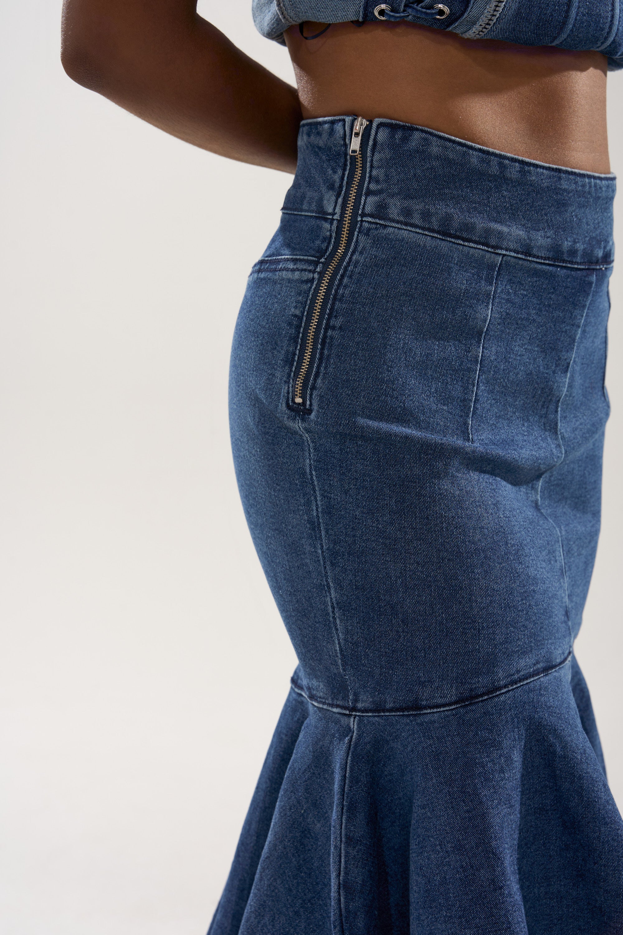 Someone wearing the YOU WISH DENIM MIDI SKIRT—high-waisted, dark blue with a visible side zipper and flared hem—photographed from the waist down against a plain background. 6