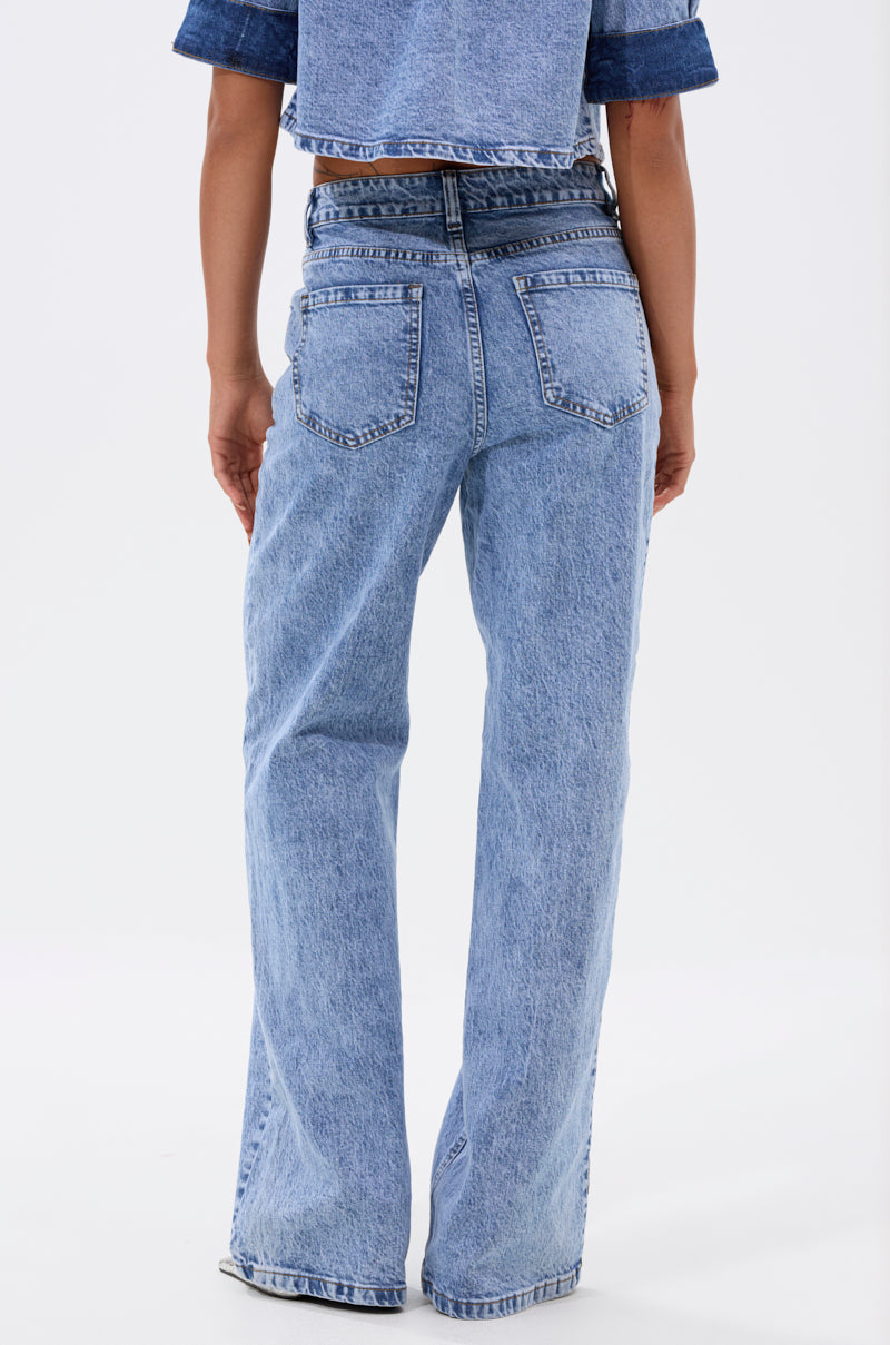 A person stands with their back to the camera, wearing ELEVATED RELAXED DENIM—light blue, high-waisted, straight-leg jeans with a relaxed fit and a cropped denim jacket for an elevated look. 5