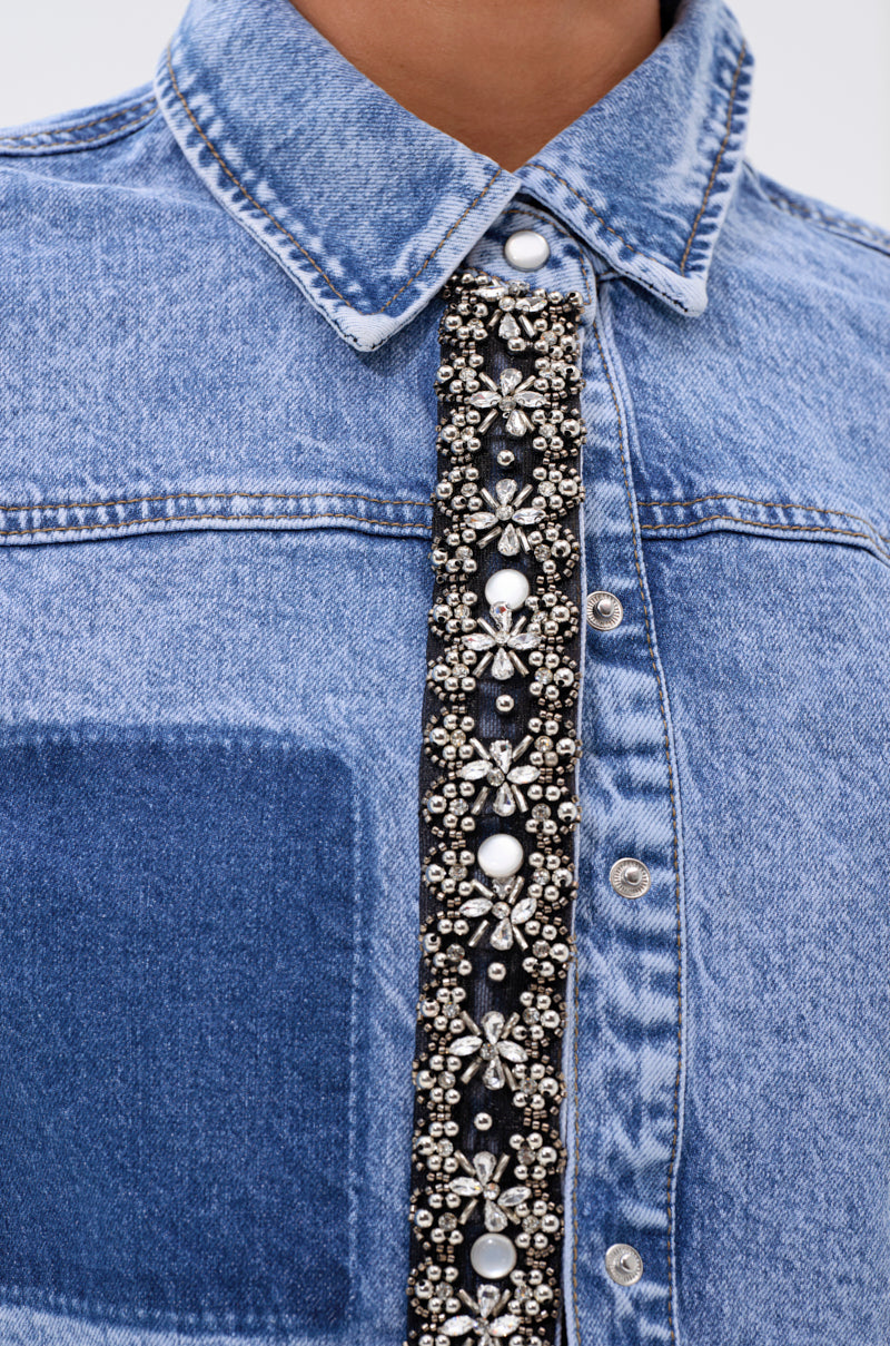 Close-up of the ELEVATED DENIM BUTTON DOWN, a dual-tone denim shirt featuring a beaded and jeweled strip with pearl and silver floral embellishments along the button placket. 6