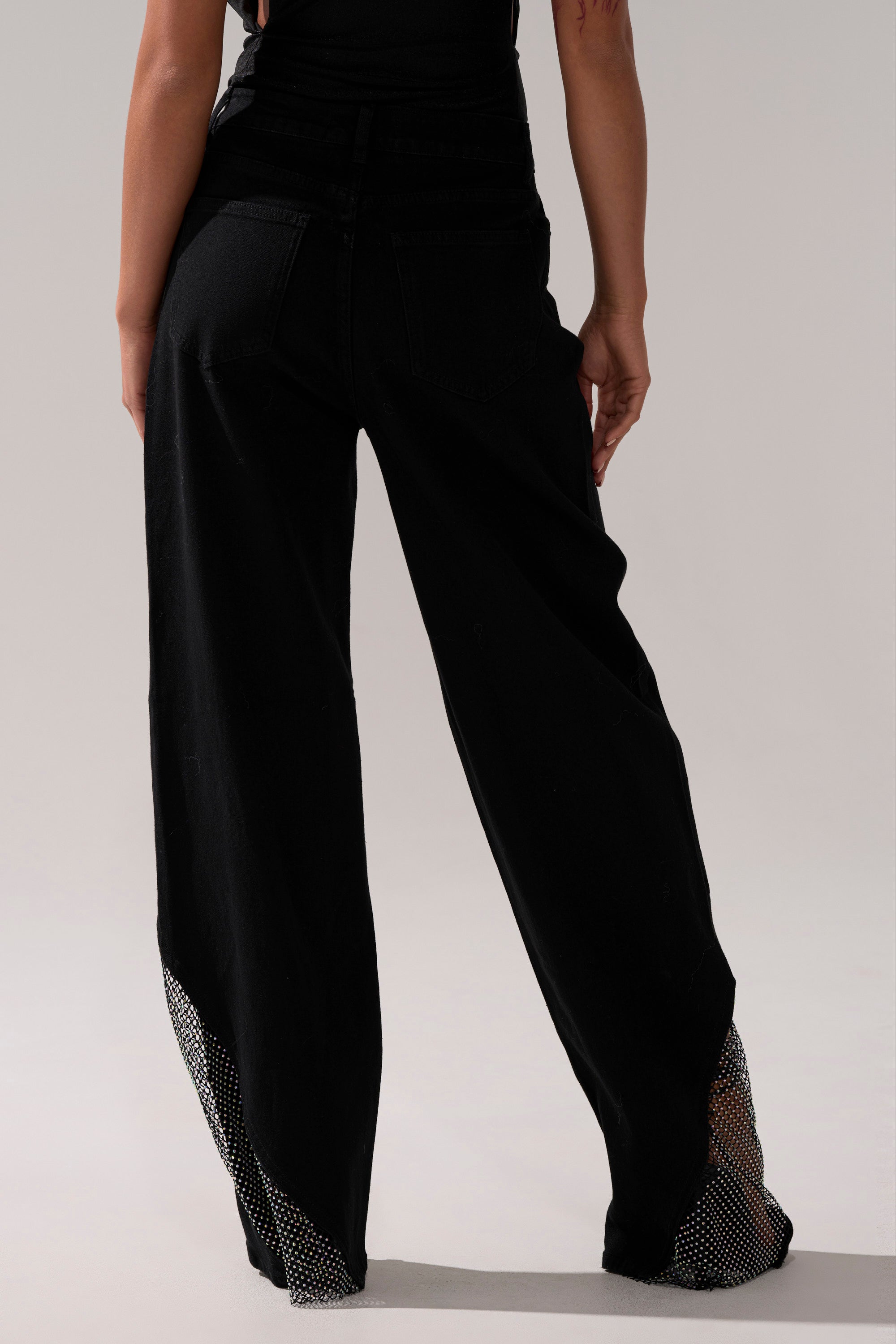 A person wearing SOMETHING DIFFERENT RELAXED DENIM WITH RHINESTONE MESH jeans.
