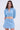 A woman with long wavy brown hair wears the ICY BLUE SPARKLE CARDIGAN and a matching mini skirt, standing against a plain light background and looking directly at the camera.