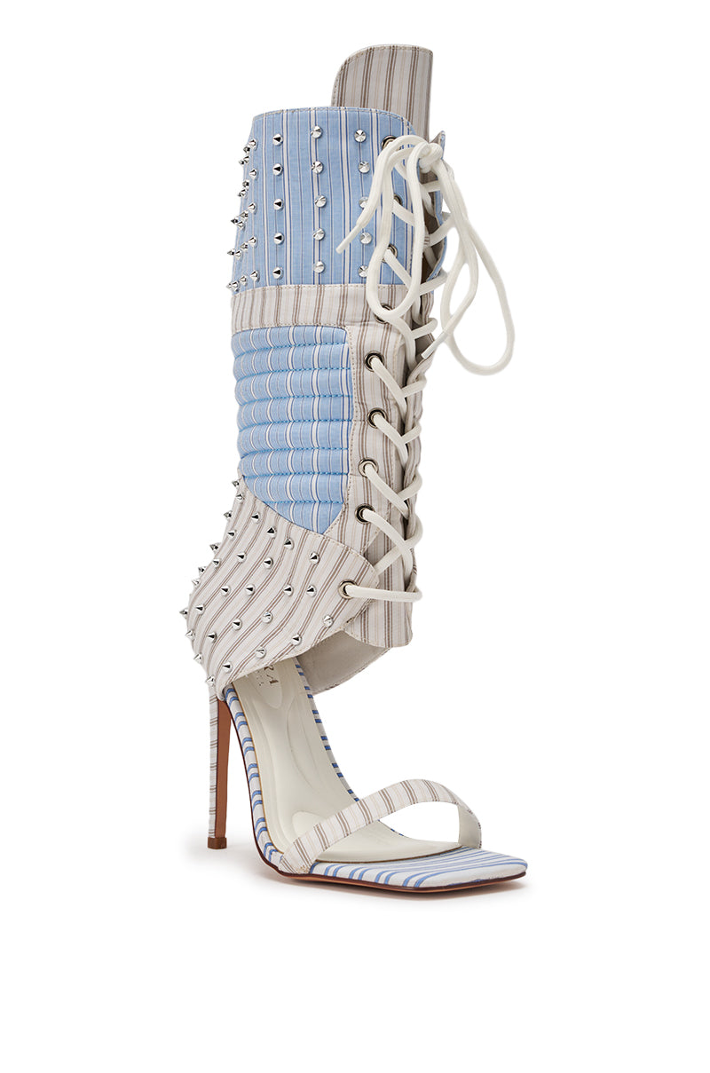 The AKIRA GOLD ALBERTO BLUE STRIPE PATTERN GLADIATOR STILETTO is a fashion-forward sandal featuring bold blue and white stripes, a tall lace-up style, silver stud accents, quilted fabric panels, and an open toe and heel. 4