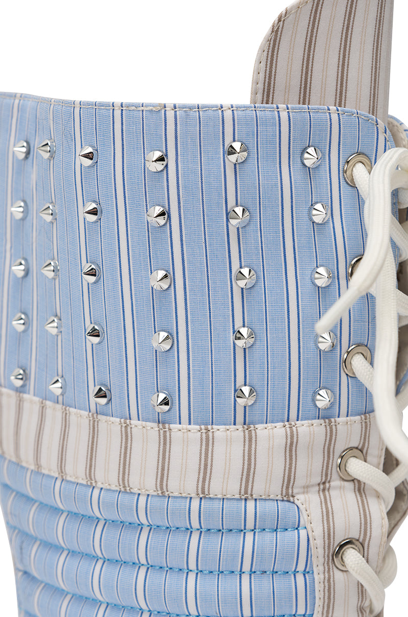 Close-up of a blue and beige striped fabric corset with silver studs, white side lacing, vertical stitching, and metallic eyelets. Style it with the AKIRA GOLD ALBERTO BLUE STRIPE PATTERN GLADIATOR STILETTO for a bold, fashion-forward look. 6