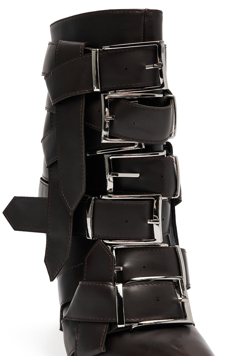 The AZALEA WANG ALCETAS CHOCOLATE STILETTO BOOTIE WITH BUCKLES features dark brown faux leather, five large silver buckles with thick straps, visible stitching, and a bold, edgy design. 6