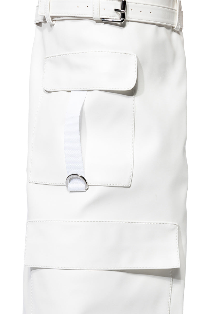 Close-up of a white garment with a pocket flap and strap, paired with a belt and metallic buckle at the waist, styled with the sleek AZALEA WANG ALEXIA WHITE WEDGE BOOT. 6