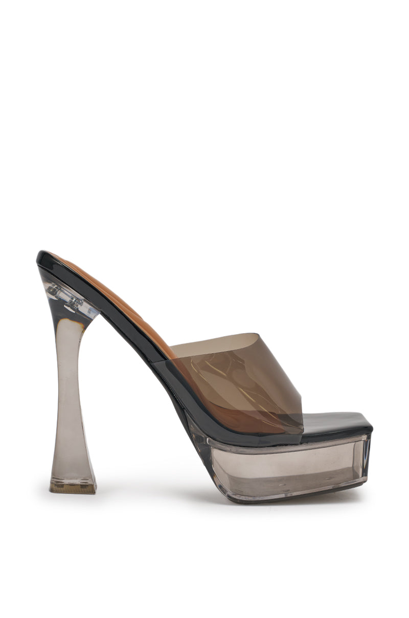 The AKIRA ALEXUS SMOKE PVC CHUNKY SLIP ON SANDAL is a high-heeled mule with a smoky gray transparent upper, sculpted clear platform, chunky heel, and open toe design. 7