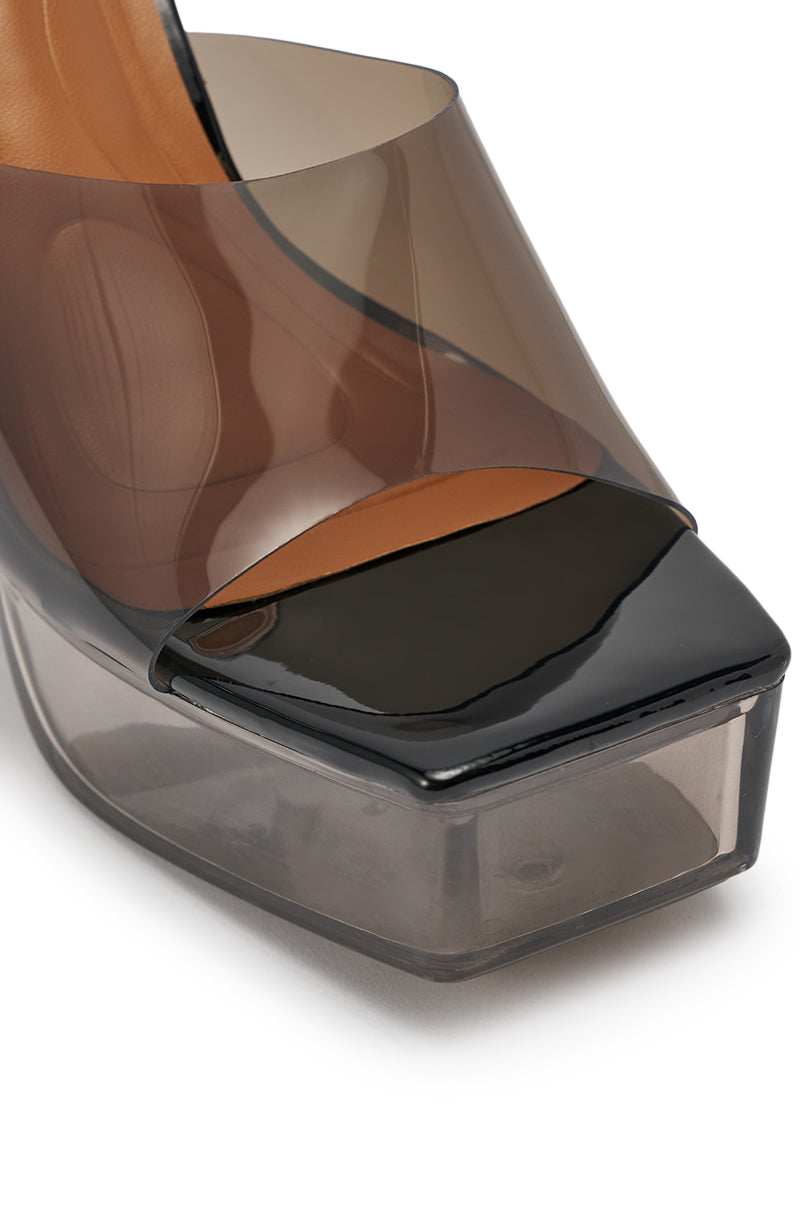 Close-up of the AKIRA ALEXUS SMOKE PVC CHUNKY SLIP ON SANDAL featuring a chunky heel, clear PVC platform sole, black open-toe front, and translucent smoky brown upper strap. 10