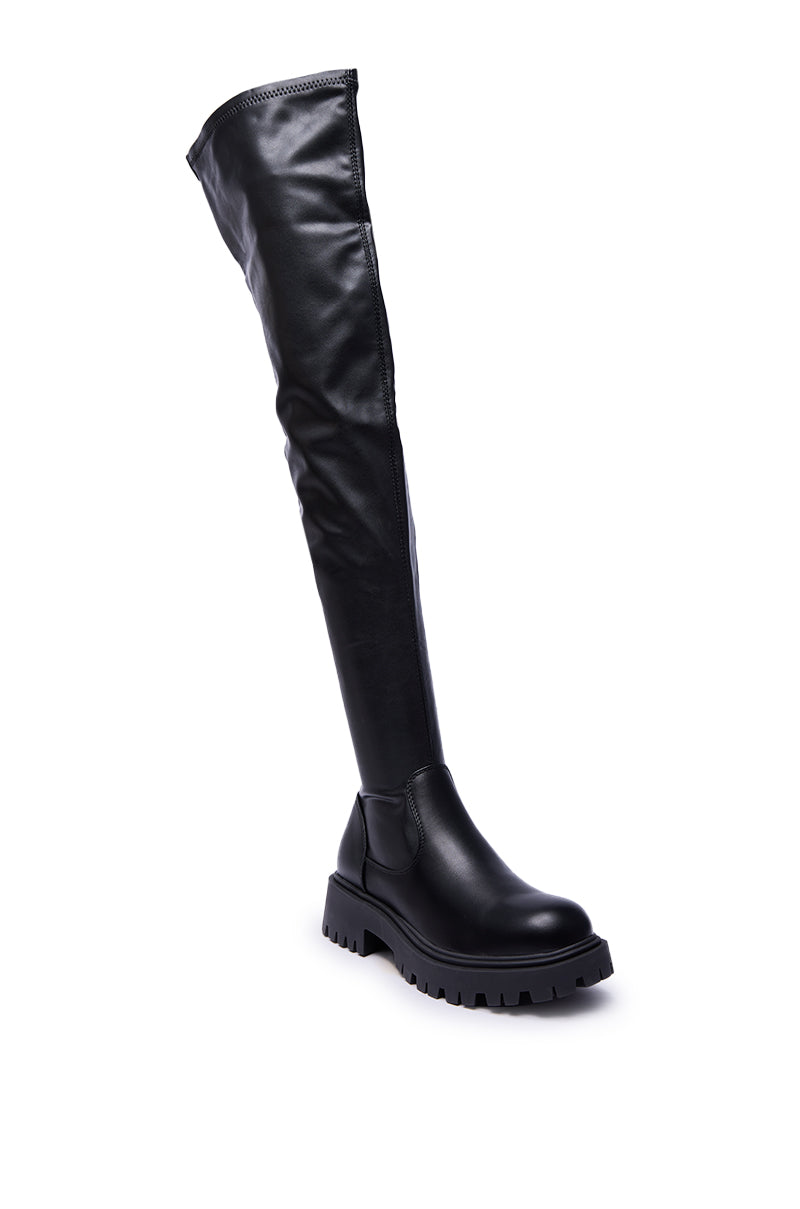 The AZALEA WANG ALINAFE BLACK OVER THE KNEE STRETCH PU BOOT features a chunky sole and smooth, matte faux leather finish, displayed solo against a white background.