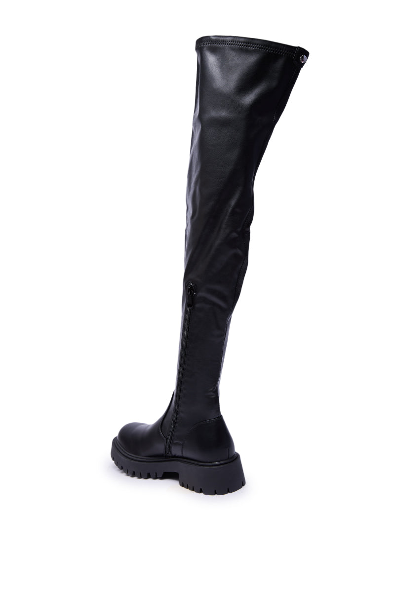 The AZALEA WANG ALINAFE Black Over The Knee Stretch PU Boot features sleek faux leather, a chunky sole, and a side zipper, shown solo on a plain white background.