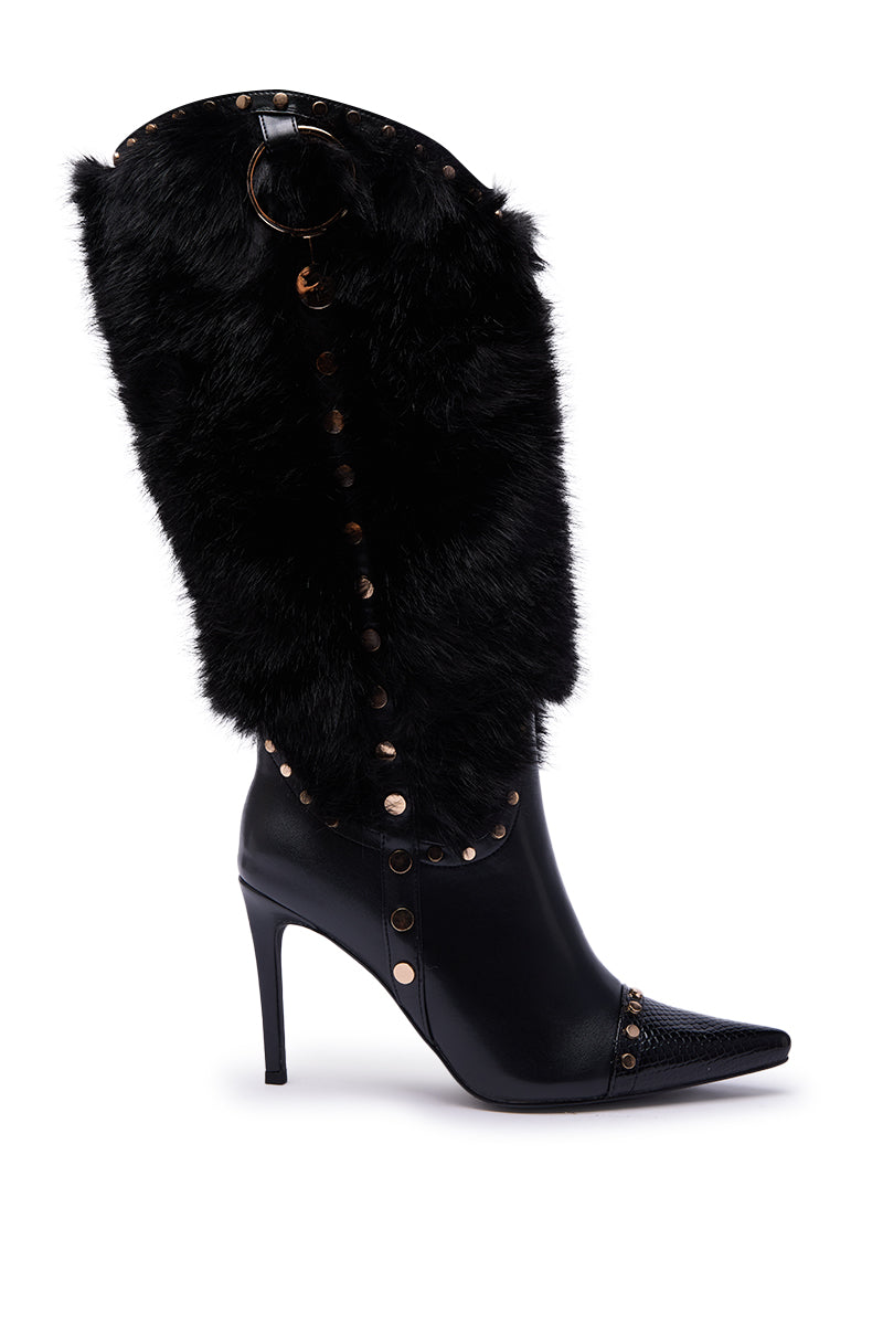 The AZALEA WANG ALISETTE BLACK FUR BOOT features a stiletto heel, pointed toe, faux fur shaft, gold studs, and decorative rings, blending leather and fur textures for a bold, fashionable style.