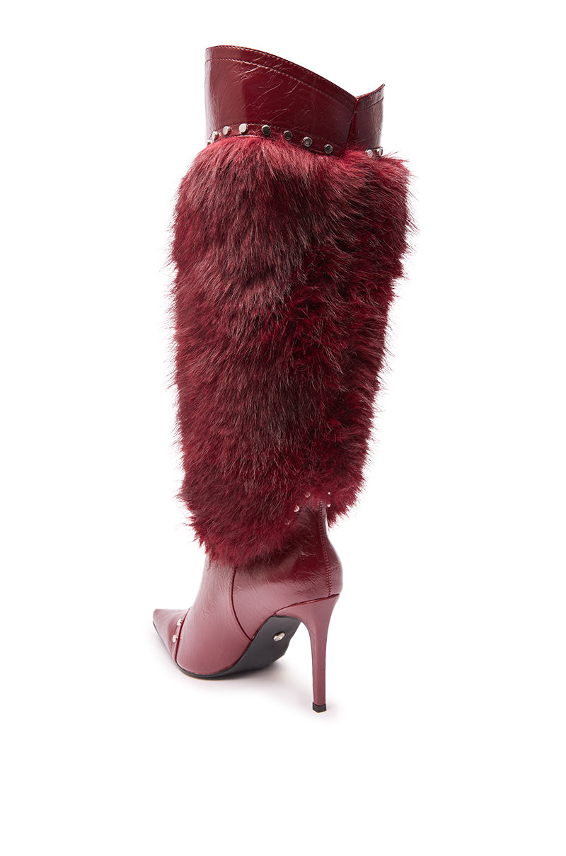 The AZALEA WANG ALISETTE Burgundy Mixed Material Fur and Snake Stiletto Boot features a deep red faux leather upper, pointed toe, tall shaft, red faux fur side panel, and silver studs along the top edge.