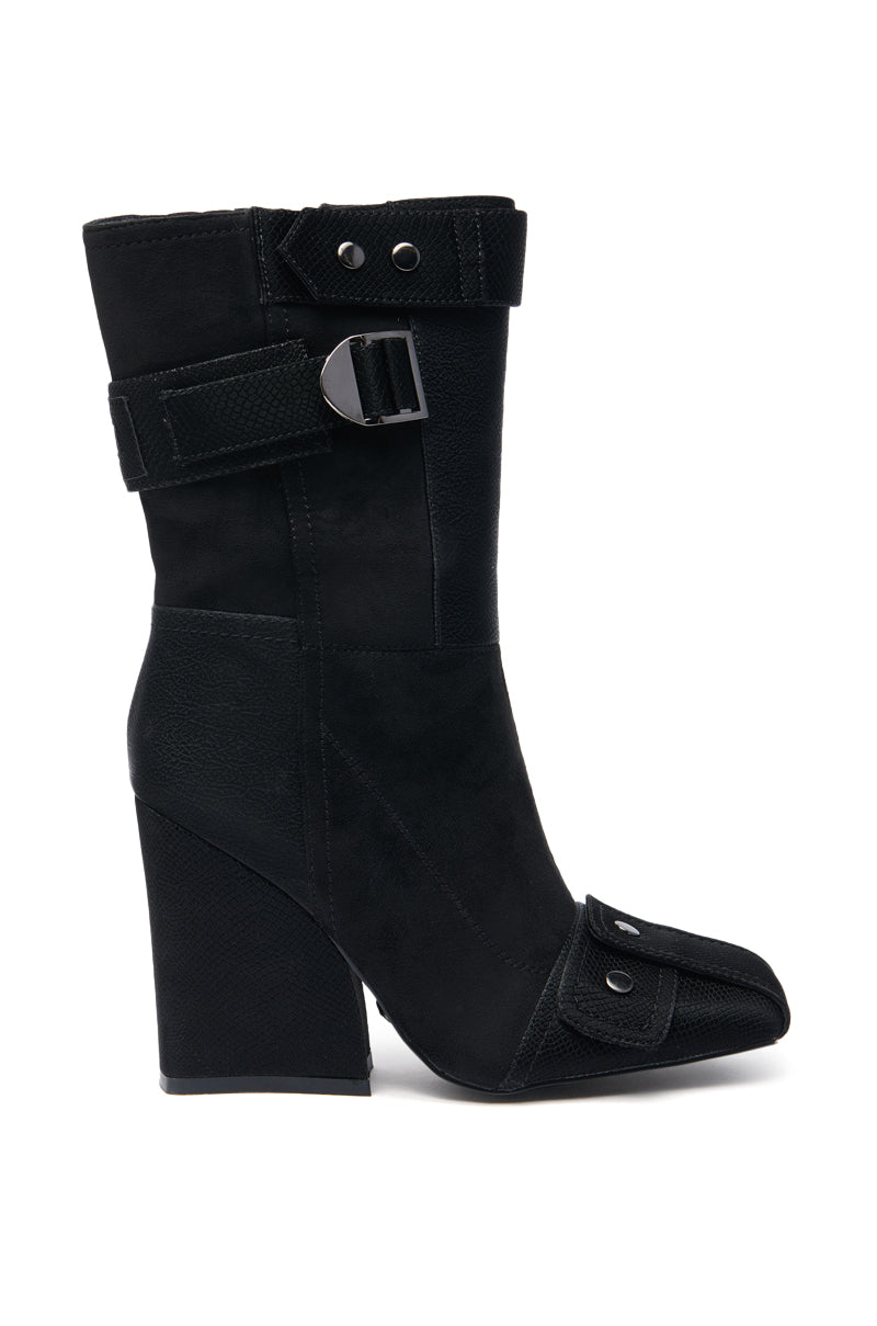 The AZALEA WANG ALLONA BLACK CHUNKY BOOTIE features black faux suede, a pointed toe, decorative side buckles, ankle and toe straps, a textured finish, and a thick angled block heel for stylish comfort.