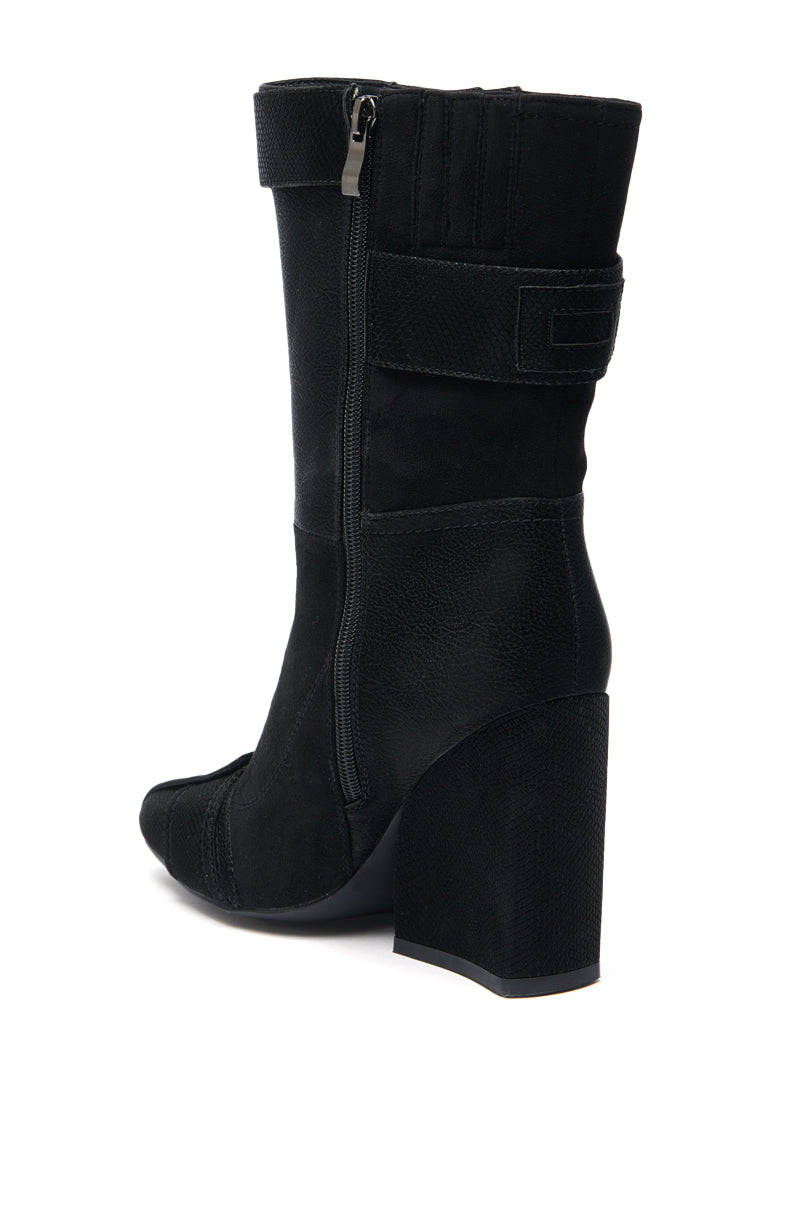 The AZALEA WANG ALLONA BLACK CHUNKY BOOTIE features a mid-calf height, side zipper, block heel, and a decorative Velcro strap around the upper shaft.