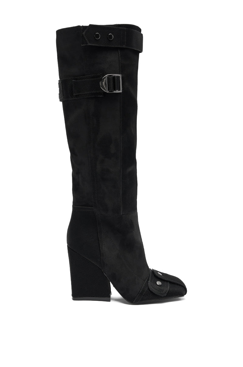 The AZALEA WANG ALLONAS BLACK KNEE HIGH CHUNKY BOOT features a square toe, decorative buckle straps at the top and ankle, and a textured toe cap with metal stud accents.