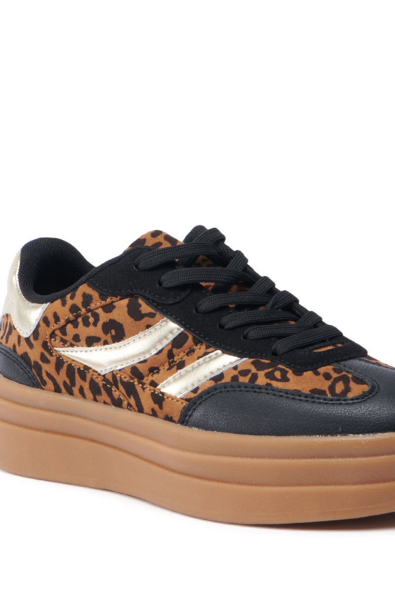 A close-up of the AZALEA WANG ALPACA MULTI LEOPARD PLATFORM SNEAKER highlights its faux suede upper with black laces, a thick brown sole, and metallic leather accents on the sides. 6