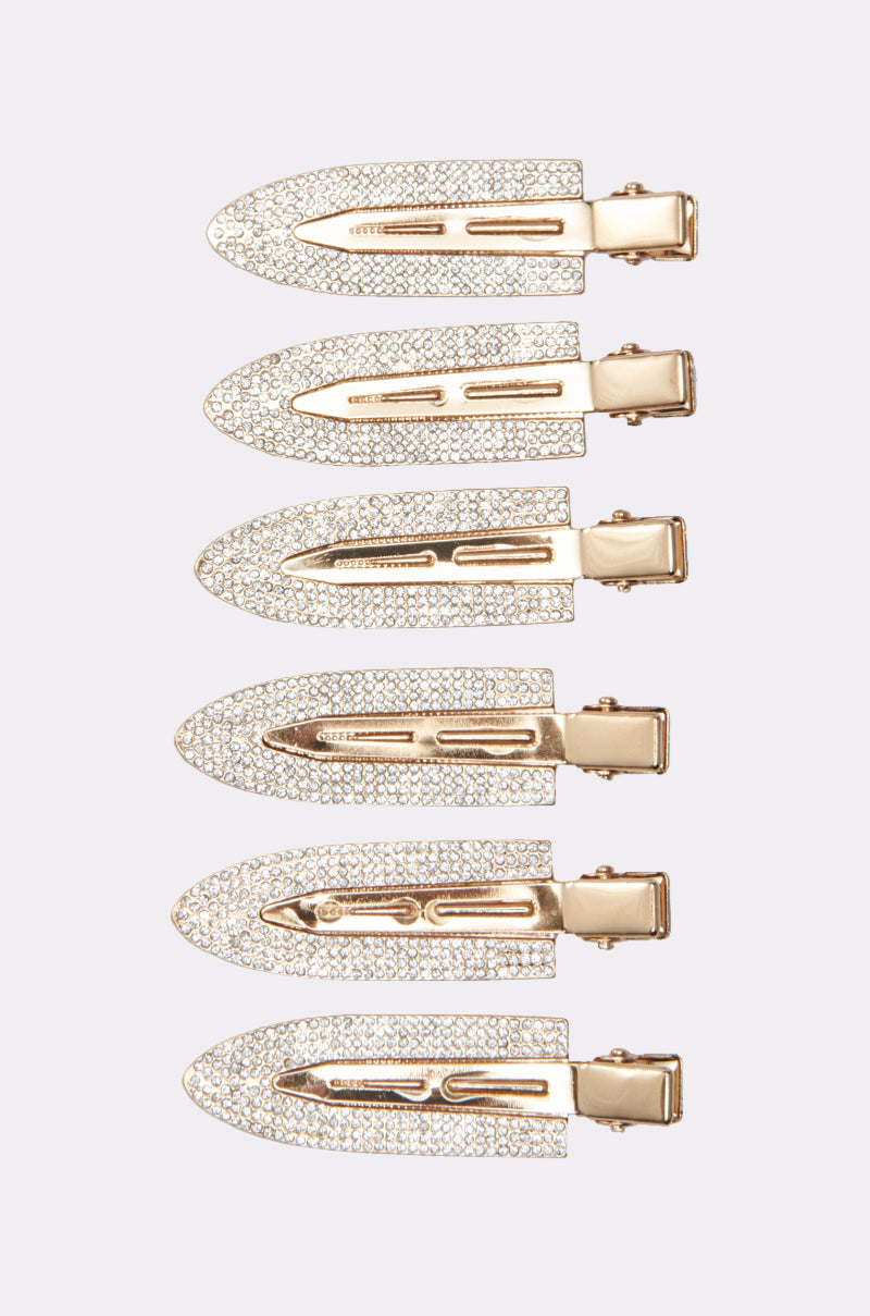 Six TOO PRETTY FOR THIS BLING HAIR CLIPS, each gold-tone and sparkling with rhinestones, are arranged vertically on a plain light background. These elegant alligator hair accessories add shiny style to any look.