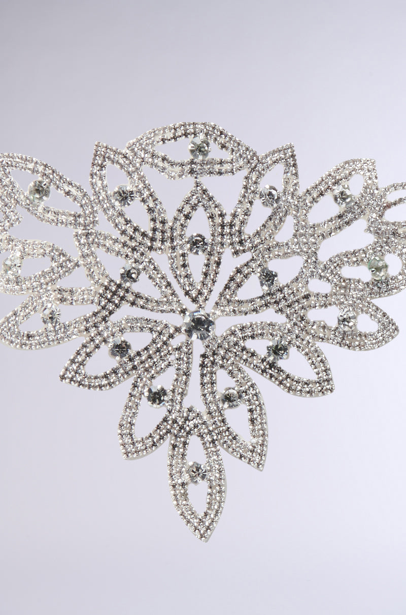 The MY LIFE IS ART CHOKER is a striking piece, featuring an intricate floral design with sparkling clear rhinestones and delicate silver details—a true statement accessory for any occasion.