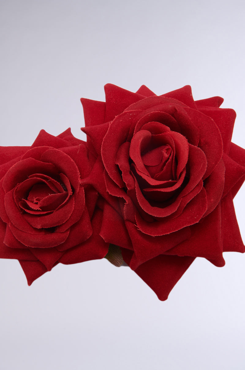 The Dolce Vita Rose Hair Clip is epitomized by two large, detailed red roses set against a light gray background. Their soft petals and natural appearance highlight the accessory's rich color and intricate layers, exuding an air of elegance and sophistication. 4