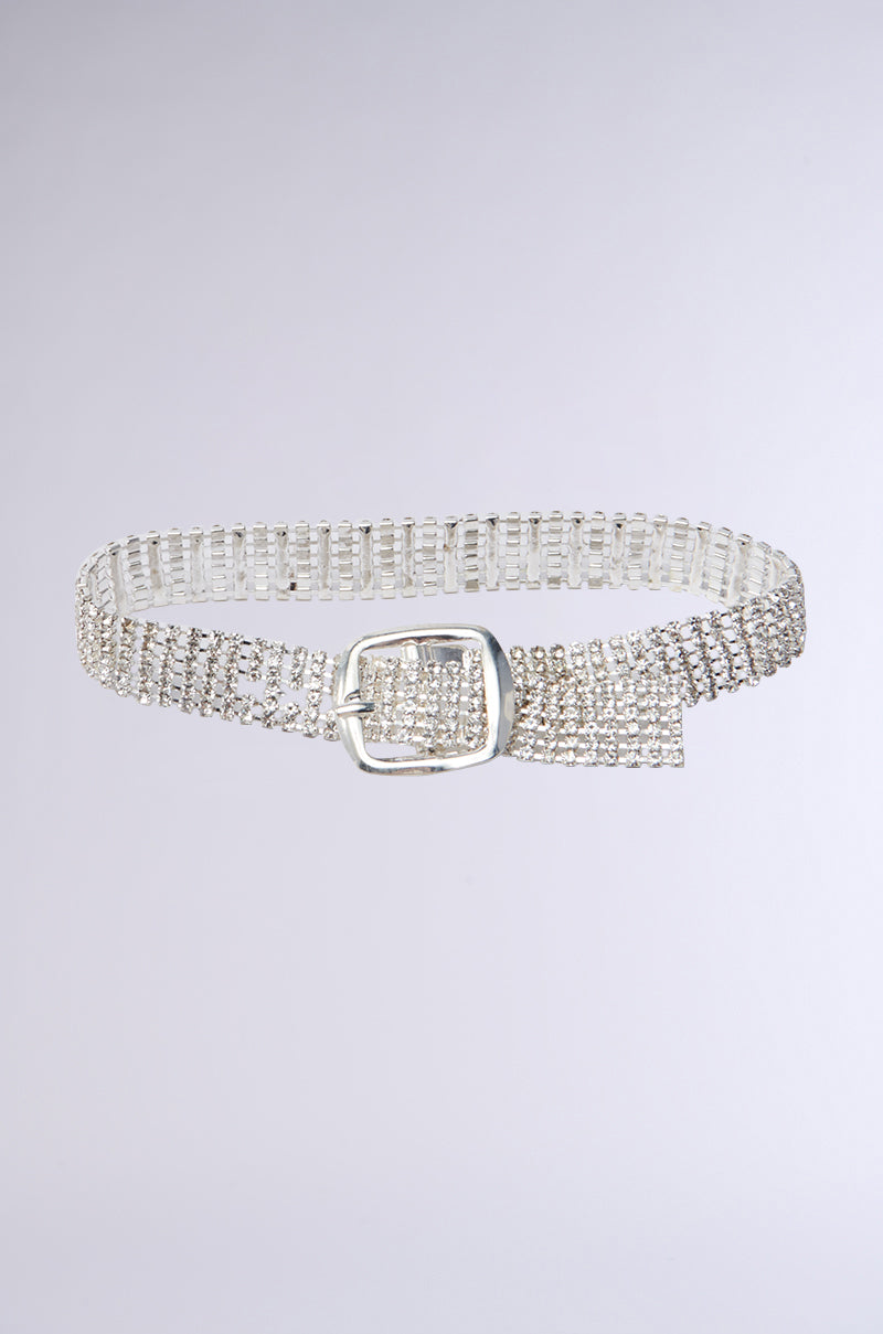 A silver belt with rhinestone links and an adjustable buckle closure features a rectangular buckle, echoing the luxurious shimmer of the Buckle Up Bling Anklet against a plain light gray background.