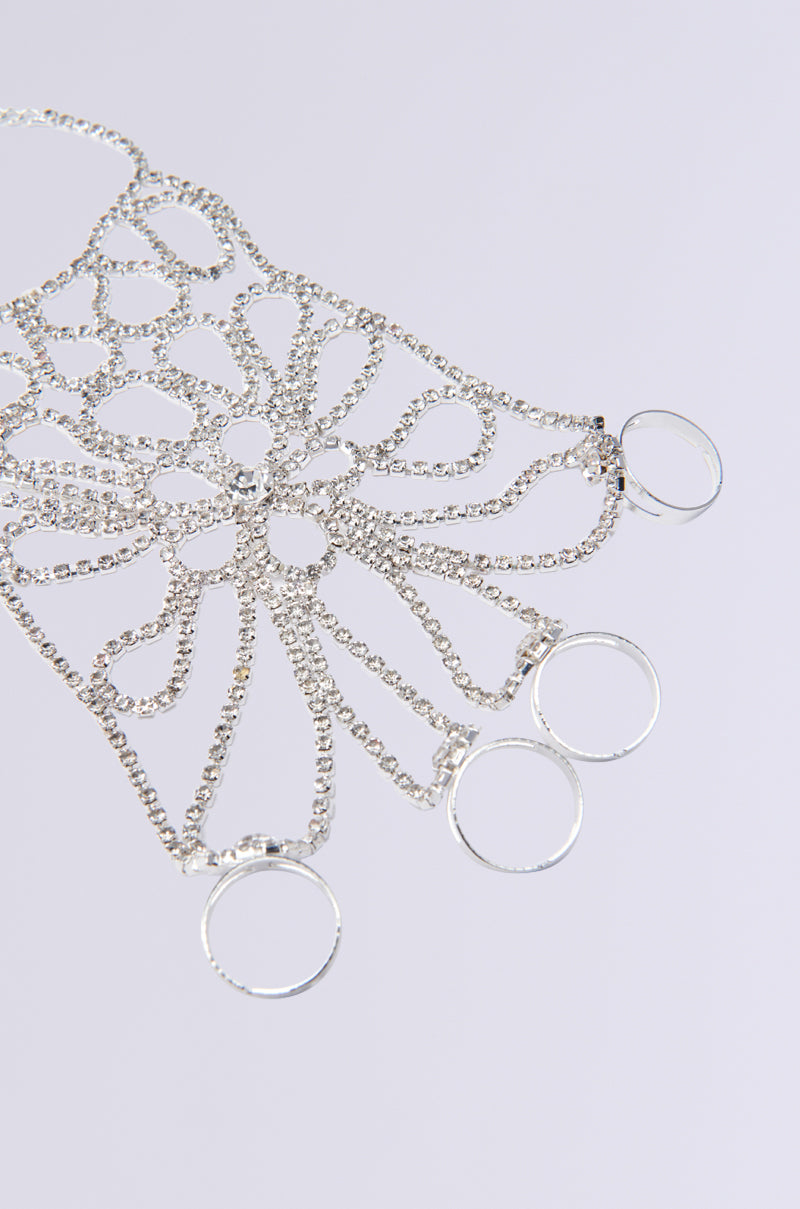 The "I DESERVE IT ALL BRACELET AND RINGS" features intricate silver hand jewelry with a web-like pattern, four attached rings, rhinestone links, and interlinked chains forming elegant loops. It is showcased on a light gray background. 2