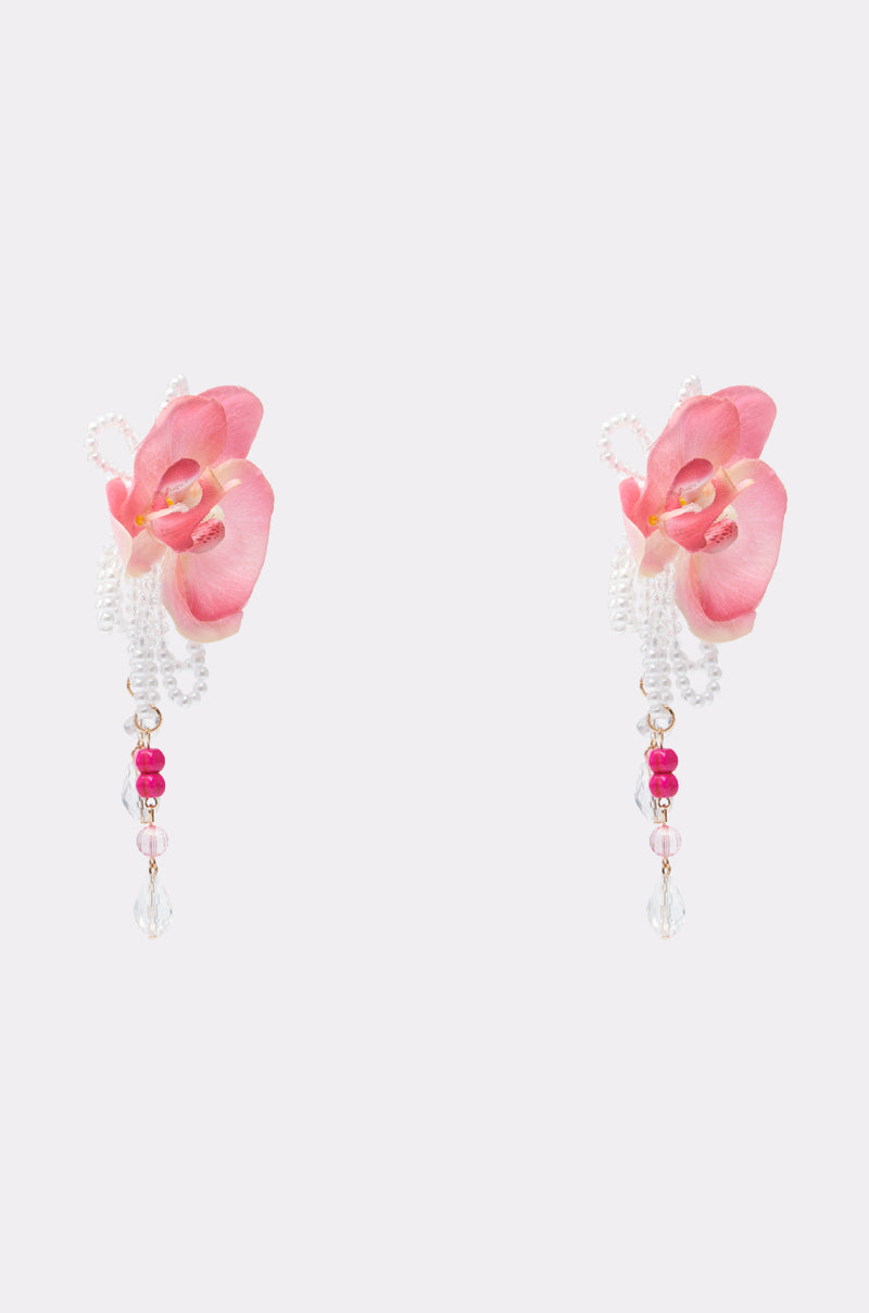 The TO THE TROPICS EARRING features pink floral petals with beaded details and dangling pearls, showcasing translucent and bright pink beads—perfect for elevating your resort wear, shown on a light background. 3