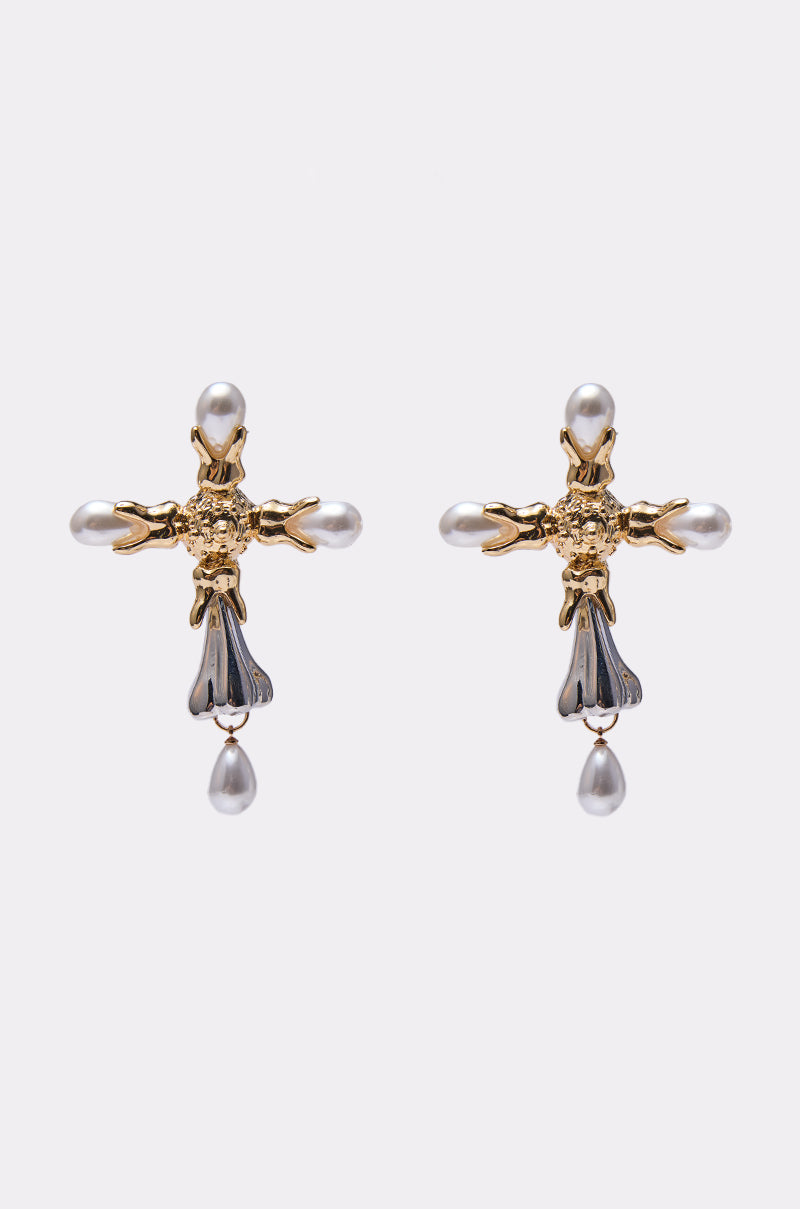 The MILAN EARRING features a gold cross shape with faux pearls at each end and a dangling pearl below, showcased on a plain white background. 0