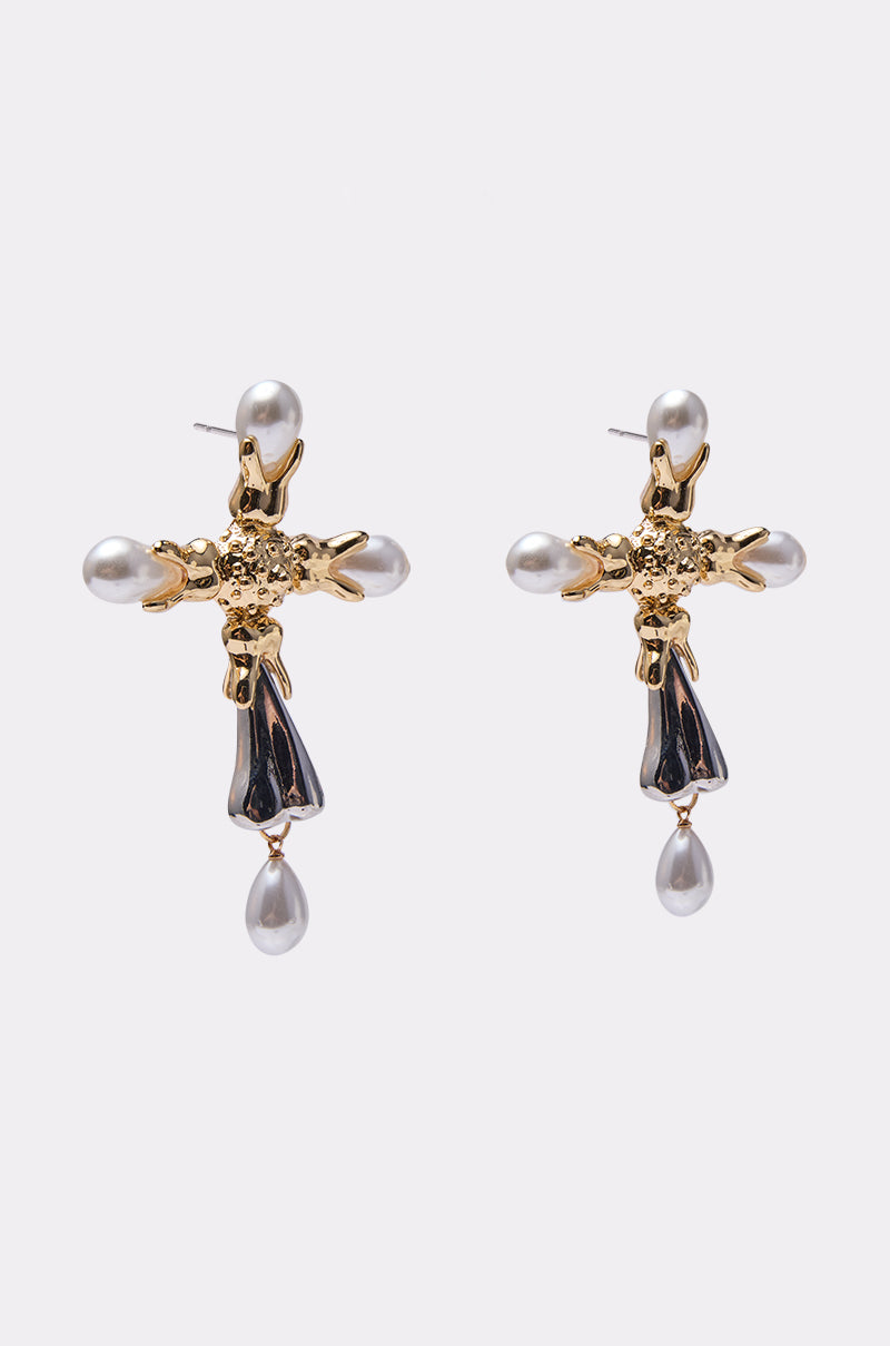 The MILAN EARRING showcases oversized gold cross earrings with faux pearls at the tips, a teardrop pearl drop, and elegant black enamel details. 2