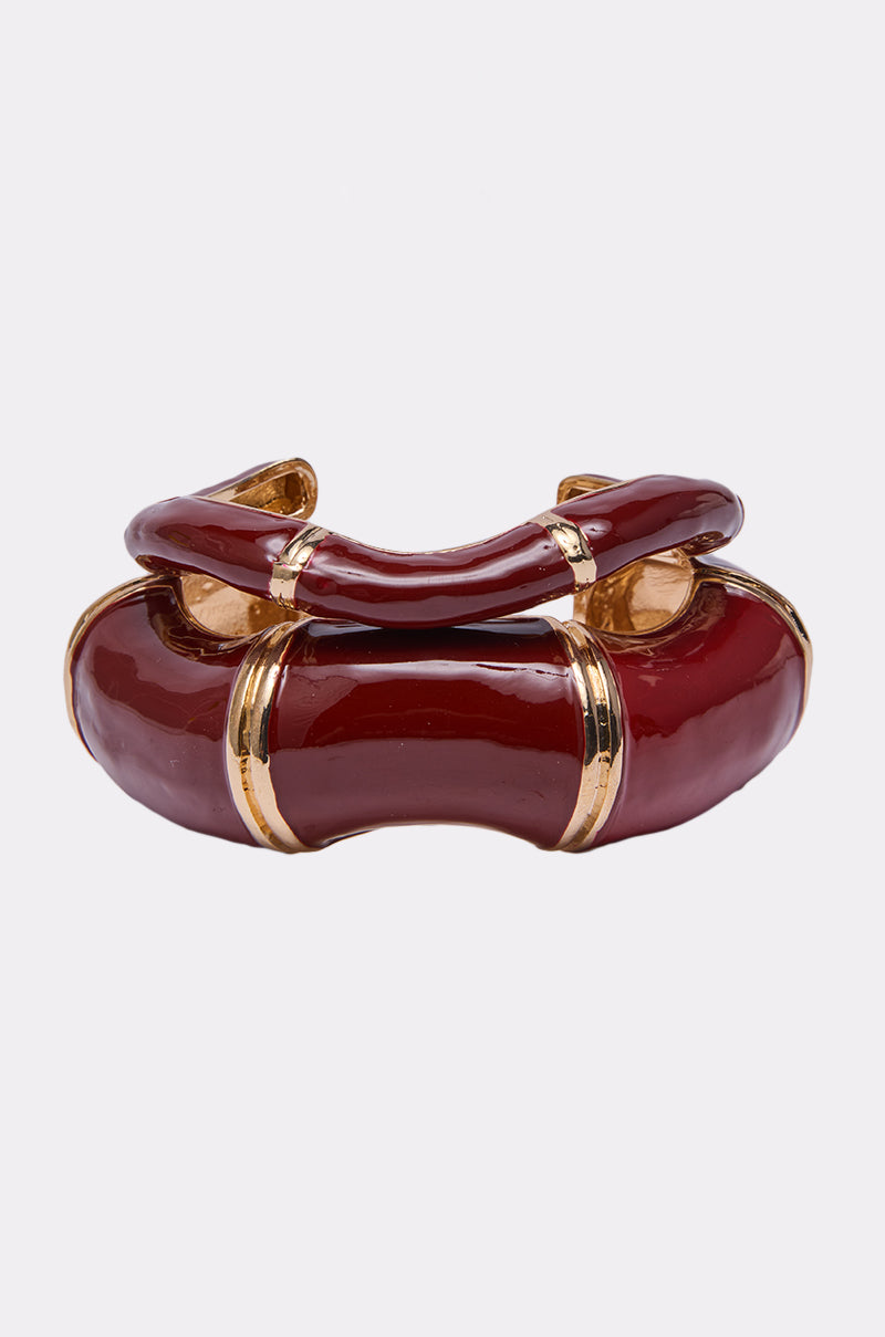 The LOLA BRACELET SET features chunky, glossy red and gold-tone cuffs with curved designs. Shiny red enamel sections are accented by gold bands for a bold, elegant style that stands out in any bracelet collection. 0