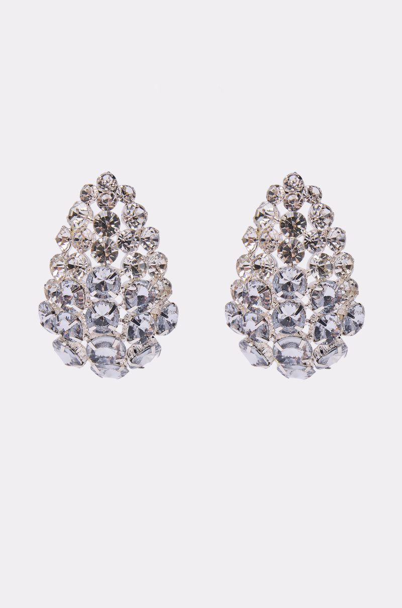 The NIGHT IS YOUNG EARRING features glamorous crystal statement earrings with multiple sparkling clear gemstones in a clustered, layered teardrop design, set against a plain white background.