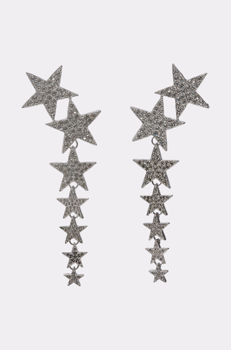 The STARGURL EARRING is a silver dangle earring with five glittery star pendants and rhinestone accents arranged vertically, shown against a white background. 2