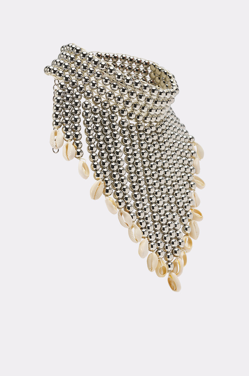 The TOO CHIC SEASHELL NECKLACE features a metallic choker design with layered silver beads forming a V-shape and cascading strands, each tipped with small cream-colored seashells. Displayed on a plain, light background. 3