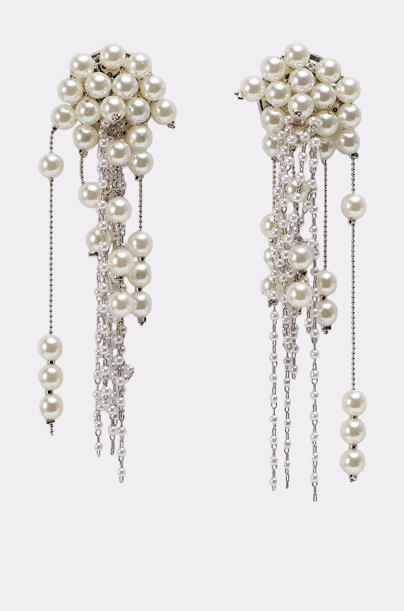 The DRIPPIN IN PEARLS EARRING showcases clusters of white pearls atop cascading strands of pearls and silver chains in varying lengths, creating a bold and elegant statement accessory. 2