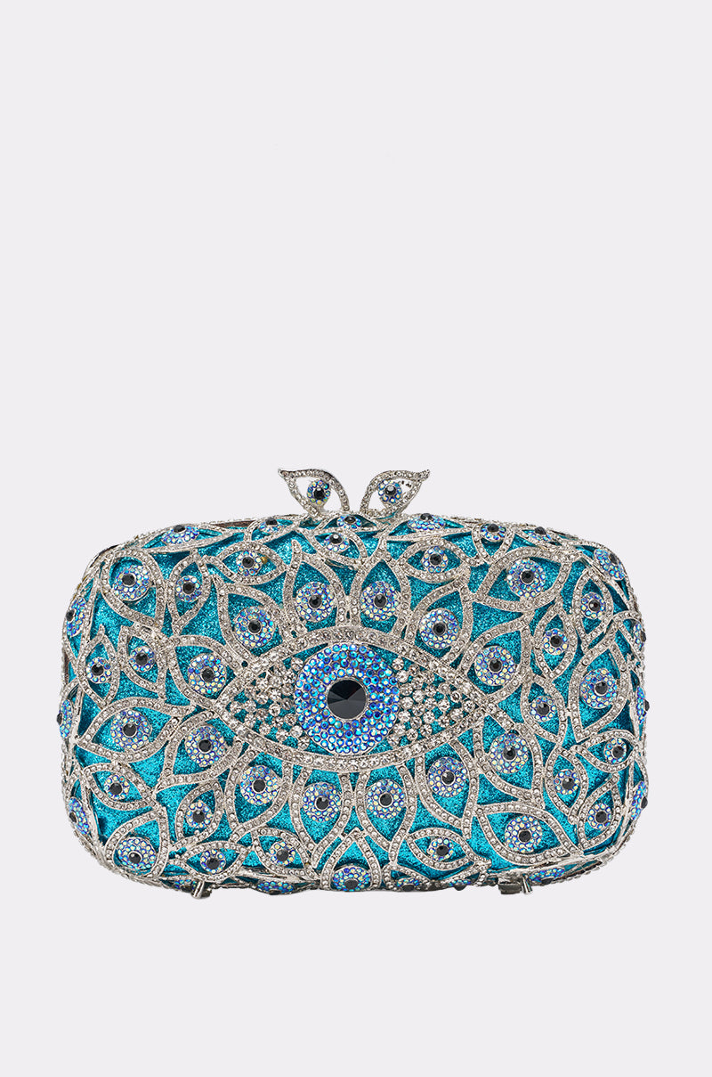 The PROTECTED BLING CLUTCH is a small rectangular blue hardshell purse with silver and blue crystal designs, a central black gem, and a unique leaf-shaped clasp at the top.