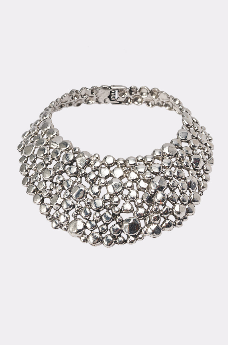 The COOL GIRL NECKLACE is a chunky, silver statement piece with sculptural, clustered metallic beads that stand out boldly against a plain white background.